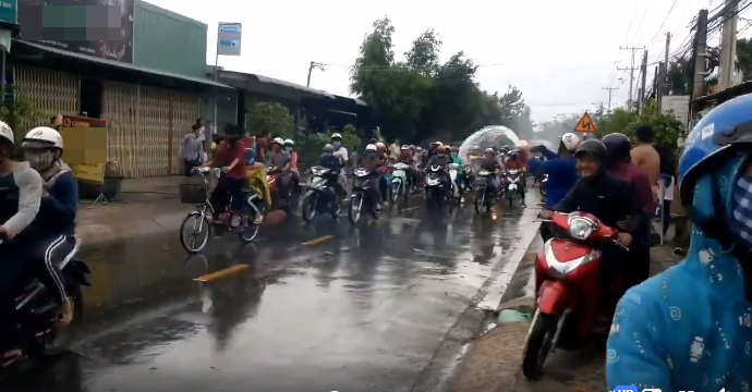 
Bất kỳ ai đi qua dù là xe đạp xe máy hay người lớn, trẻ nhỏ đều bị tạt nước ướt nhẹp. (Ảnh cắt từ clip)