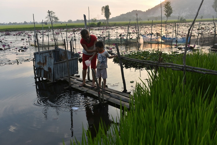 Hoạt động sinh hoạt của chị Phạm Thị Lan (31 tuổi) cùng con trai (4 tuổi) tại trại nuôi cá thuộc thôn Vĩnh Xuyên, huyện Tịnh Biên, tỉnh An Giang, Việt Nam. (Ảnh: Andrea Bruce)