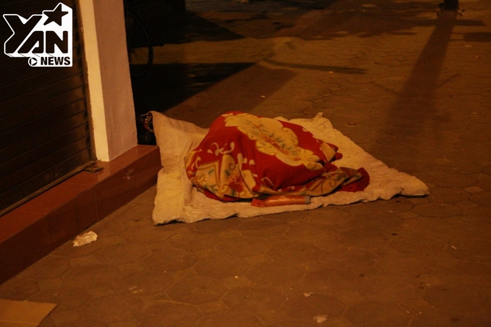 
Một người đang ngủ say trên đường Nguyễn Thái Học - Hà Nội. Họ thường có thói quen phủ kín chăn từ đầu đến chân rồi nằm cuộn tròn mình lại như thể để bớt đi cái lạnh và sự cô đơn khi đêm về.