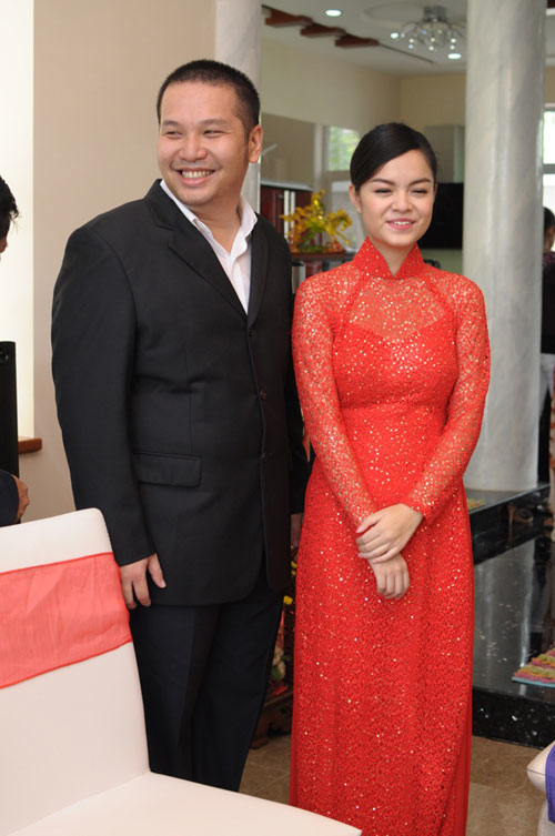 
Trong ngày trọng đại của Phạm Quỳnh Anh cùng "ông bầu" Quang Huy, cô đã chọn cho mình tà áo dài đỏ với chất liệu ren đính sequin lấp lánh, phần tà sau trải dài góp phần khiến bộ áo dài trở nên hoành tráng hơn.
