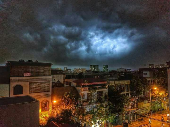 
Bầu trời cuồn cuộn mây đen vào thời khắc Hà Nội lên đèn.- Ảnh: Nam Nguyễn
