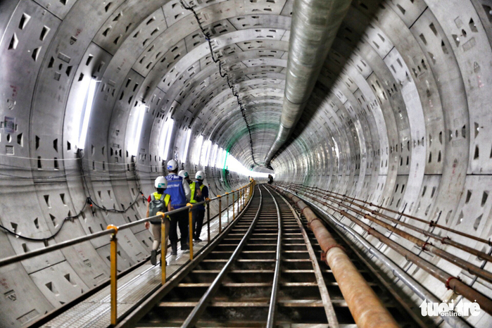 
Hệ thống chiếu sáng và đường ray được lắp tạm suốt chiều dài hầm để phục vụ công tác thi công - Ảnh: HỮU KHOA