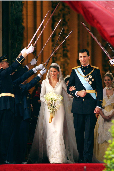 
Trong lễ cưới của Vua Felipe và Nữ hoàng Letizia Ortiz của Tây Ban Nha (2004), cô dâu ghi điểm với phong cách quý phái, thanh lịch. Bộ váy cưới có thiết kế đường viền cổ dựng độc đáo, họa tiết thêu chỉ vàng nổi bật trên nền lụa trắng ngà. 