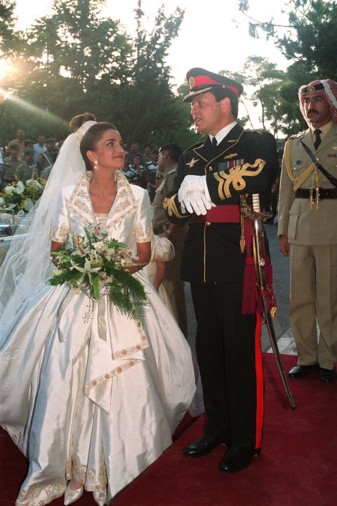 
Hoàng tử Abdullah và Nữ hoàng Rania của Jordan (1993). Bộ váy cưới của Nữ hoàng có thiết kế đơn giản, thanh thoát với đường viền cổ bẻ ấn tượng. Nữ hoàng toát lên vẻ sang trọng với chiếc vương miệng bạch kim gắn kim cương đắt giá. Trên nền vải trơn mịn là những họa tiết chỉ vàng thêu tay sang trọng. 