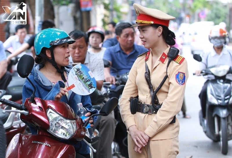 
Chiến sĩ CSGT Trần Thị Minh Huệ đang trò chuyện với một phụ huynh