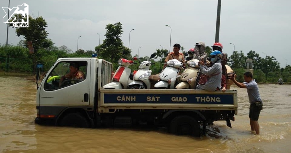 Hình ảnh đẹp ngày mưa lũ: CSGT Hà Nội dùng xe chuyên dụng giúp người dân đi qua đoạn ngập lụt sâu