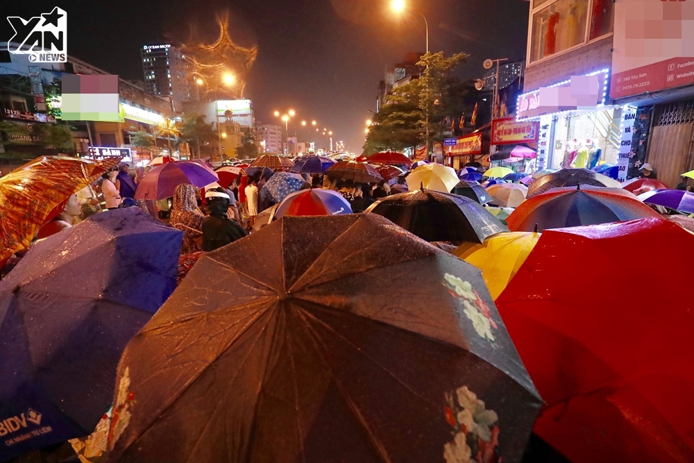 
Hàng nghìn người dân đội mưa ngồi trước cửa chùa làm lễ