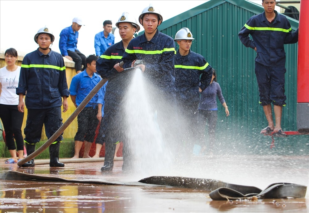
Ngày 8.8, Cảnh sát phòng cháy, chữa cháy được huy động đến phun nước, rửa sạch khuôn viên trụ sở UBND xã, trường học, trạm y tế xã và một số khu vực đã rút nước. Ảnh: Tô Thế