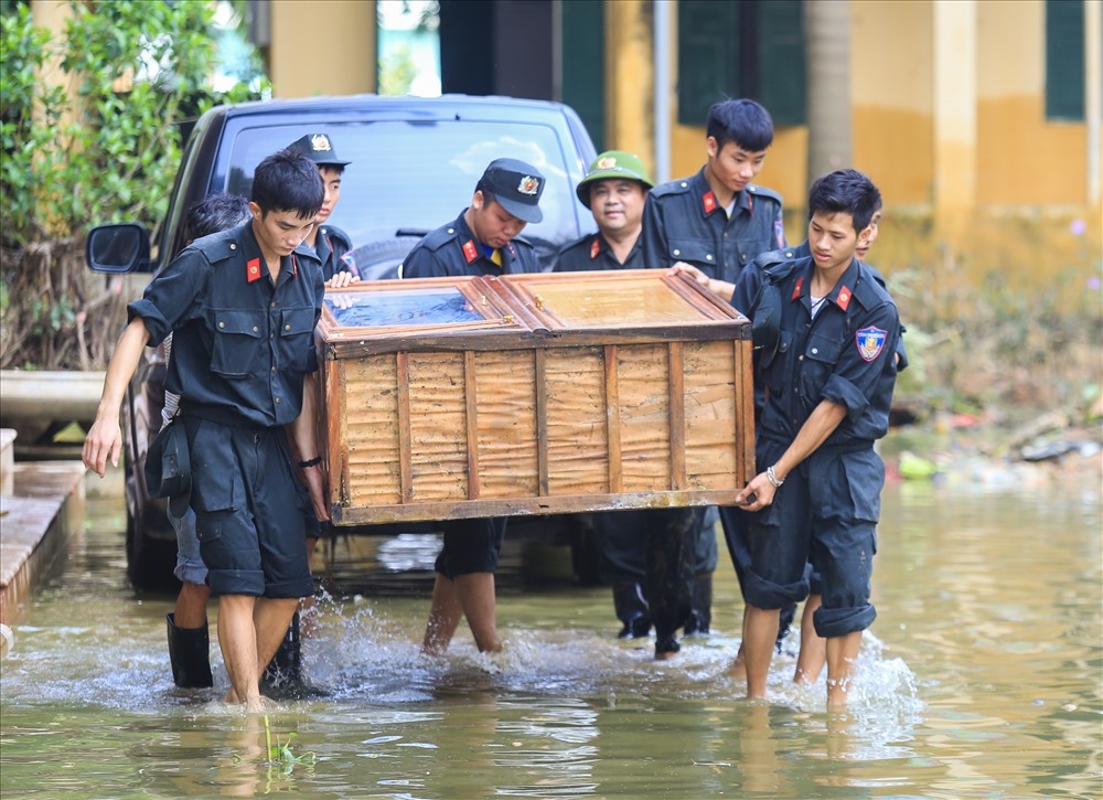 
Lực lượng cảnh sát cơ động giúp nhà trường di chuyển đồ đạc về vị trí cũ. Có khoảng 100 chiến sĩ được huy động đến giúp người dân dọn dẹp vệ sinh sau ngập. Ảnh: Tô Thế