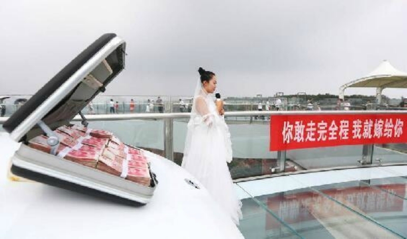 
Cô gái trẻ đem theo lễ vật là một chiếc ô tô mới toanh cùng với một vali tiền lên chiếc cầu bằng kính để cầu hôn bạn trai