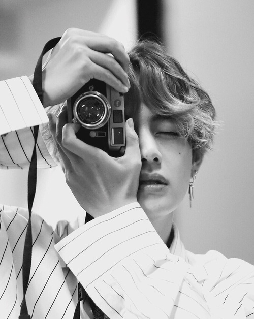 
V (BTS) tạo dáng bên máy ảnh của anh ấy.