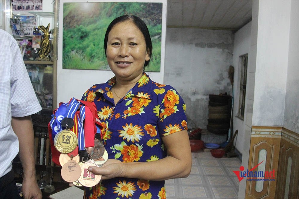 
Mẹ Minh Vương bên những huy chương của con.
