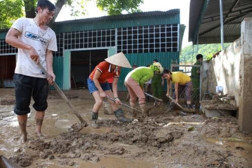 
Nhiều người được huy động để dọn bùn sau lũ tại các điểm trường bị ngập ở thị trấn Mường Xén, huyện Kỳ Sơn.