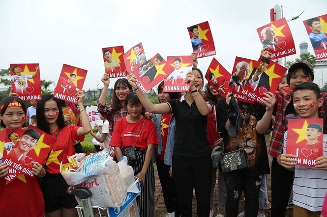 
Trời đổ mưa, nhưng người hâm mộ vẫn vây kín sân bay Nội Bài.