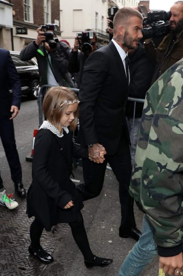 
David Beckham diện vest đen, thắt cà vạt bảnh bao nắm tay công chúa Harper đến ủng hộ Victoria. Con gái út của cựu cầu thủ cũng chọn diện đầm màu đen cùng tone với bố, tạo điểm nhấn với chiếc băng đô hoa vô cùng xinh xắn trên đầu.