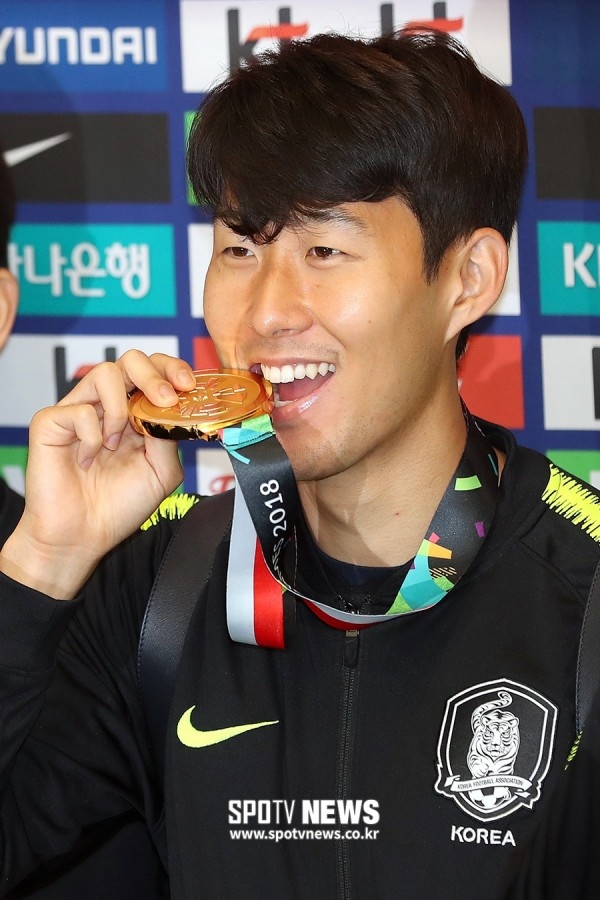 
Son Heung-min cười tươi rói với chiếc huy chương vàng trên tay, trái hẳn với biểu cảm từ vài tháng trước đó.