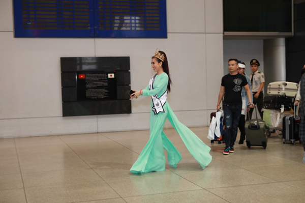 
Hoa hậu xuất hiện tại sân bay trong áo dài xanh thướt tha, mừng rỡ vì gặp lại gia đình và người hâm mộ.