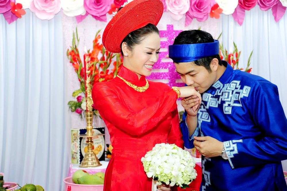 
Nhật Kim Anh cũng chọn áo dài đỏ bằng lụa Hà Đông cho lễ rước dâu nhưng cô kết hợp cùng quần lụa đen kiểu cổ điển. 