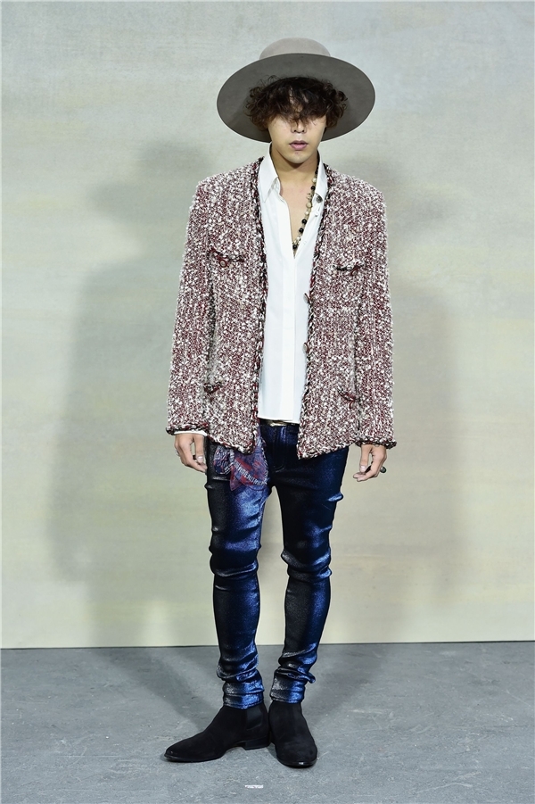 
Diện áo khoác tweed, quần ánh kim xanh và ankle boots, anh chàng còn thu hút sự chú ý tại sự kiện với mái tóc xù che nửa mặt cộp mác G-Dragon.