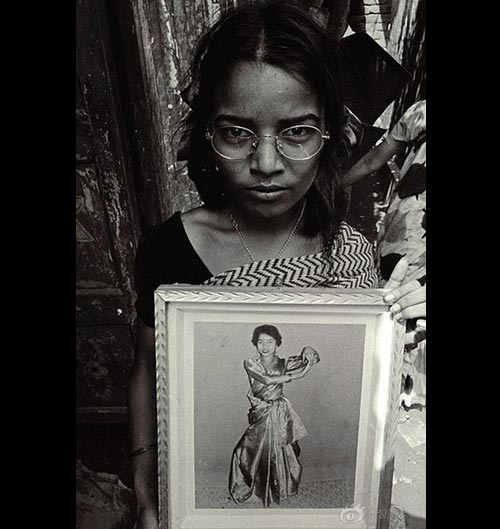 
Một cô gái Bangladesh cầm bức ảnh của mình 1 năm trước đây, khi em 15 tuổi và chưa bị bán vào đây làm gái mại dâm. Ước mơ của em là được trở thành vũ công.