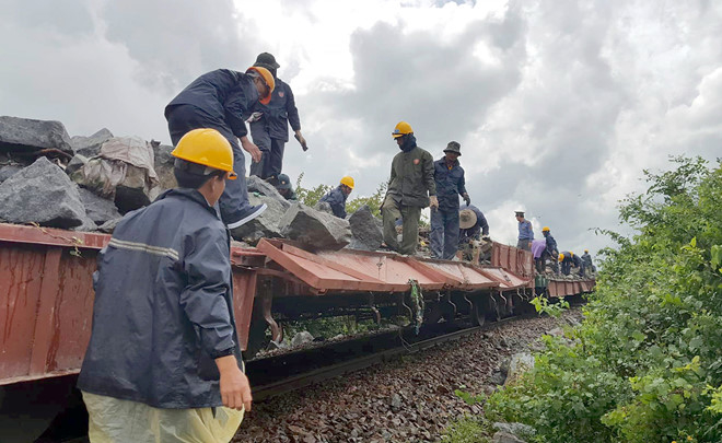 
Ngành đường sắt huy động công nhân cùng các phương tiện chuyên dụng tập kết đá gia cố đường ray bị mưa lũ cuốn trôi đất đá. Ảnh: Bình Minh.