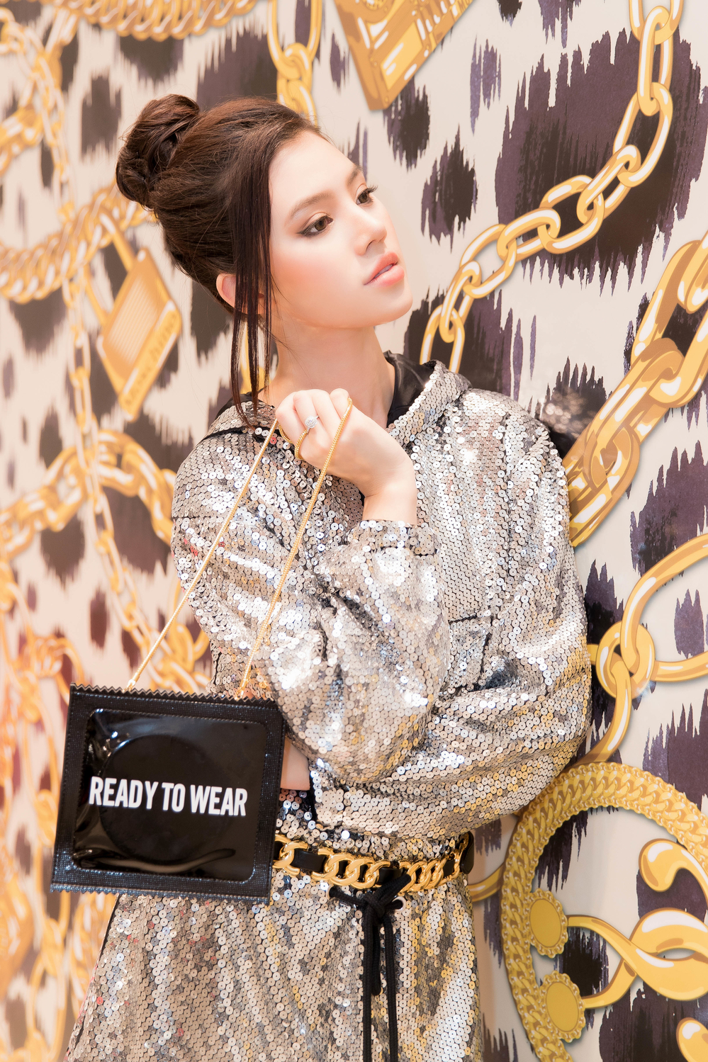 
Jolie Nguyễn xuất hiện tại sự kiện với bộ váy sequin lấp lánh, mang đậm chất thể thao. Người đẹp kết hợp với túi xách hình bao cao su độc đáo. 
