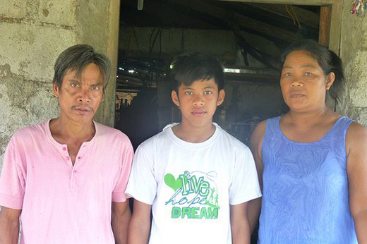 
Cậu học trò nghèo Romnick L. Blanco chụp cùng bố mẹ tại ngôi nhà của họ ở một vùng rừng núi Philippines.