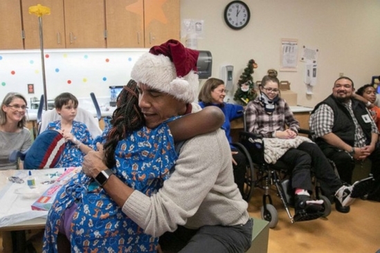 
Ông Obama ôm động viên một bệnh nhi tại Trung tâm