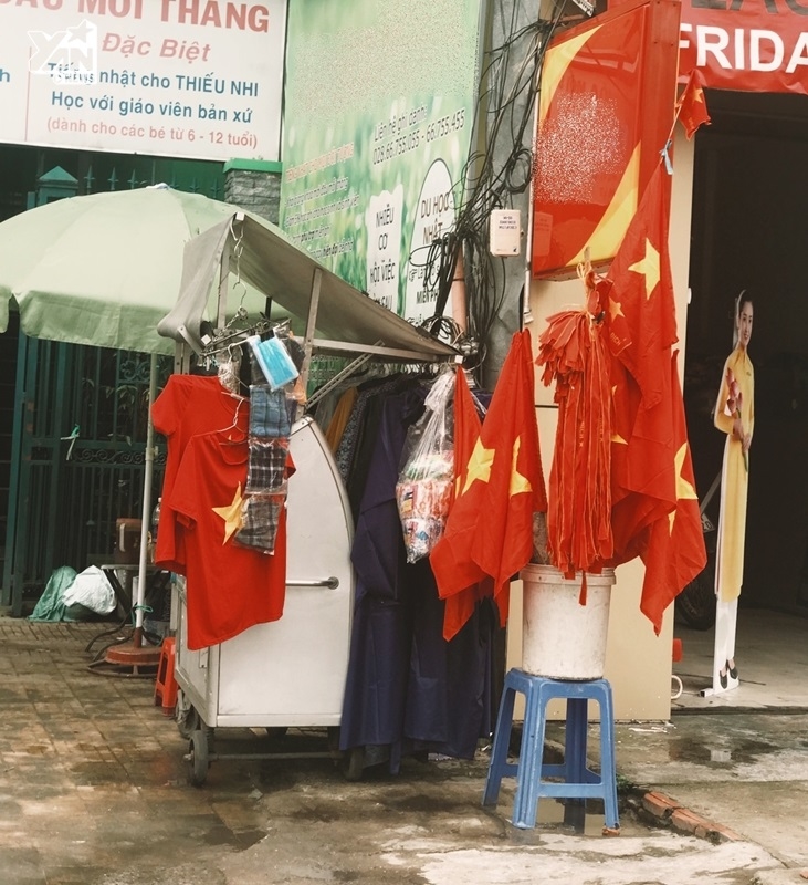 
Nhiều người tranh thủ mang các phụ kiện cổ vũ cho đội tuyển Việt Nam từ cờ, kèn, áo... để bán cho người hâm mộ.