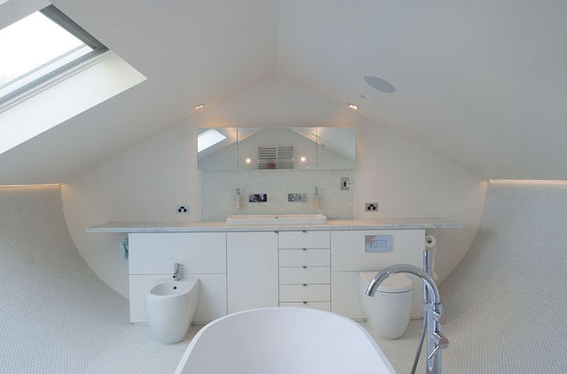 
Tầng gác mái với tông trắng này được sử dụng làm phòng tắm. Điểm nổi bật là khu vực sàn lát gạch cong khá lạ mắt.