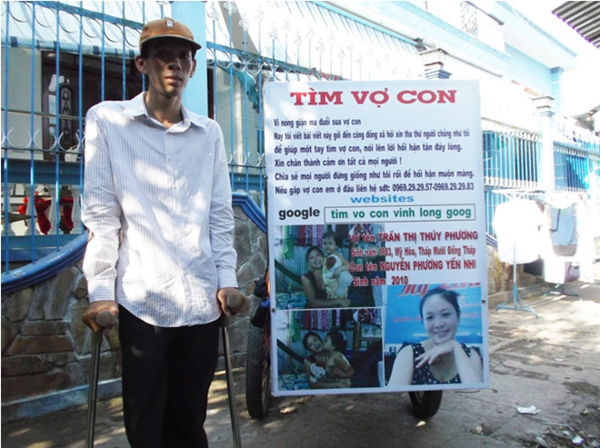 
Anh Thuận và tấm biển in hình vợ con - Ảnh: Internet