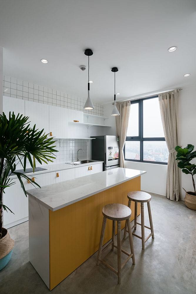 
Không gian nấu ăn cũng được nhấn nhá với tông vàng - trắng tạo năng lượng mỗi khi vào bếp