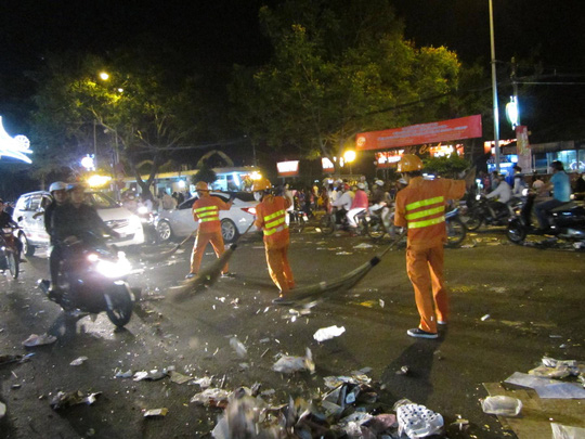 Các công nhân vệ sinh môi trường vất vả dọn rác thải trên đường phố sau đêm hội pháo hoa.