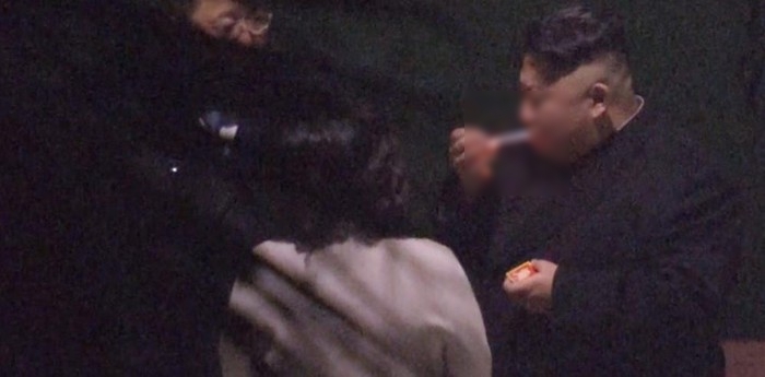 
Hình ảnh cắt từ clip cho thấy cô Kim Yo Jong đứng cầm gạt tàn bằng pha lê chăm sóc cho anh trai.

