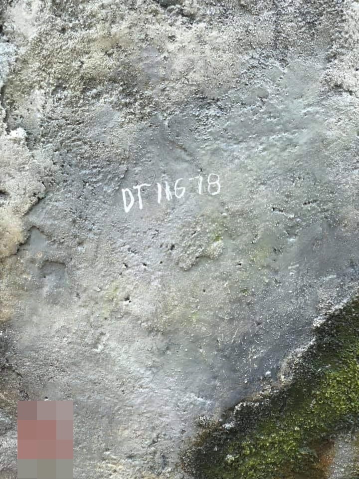  
Người đàn ông dùng bút xóa ghi viết chữ trên đá dưới ánh nhìn của hàng trăm người