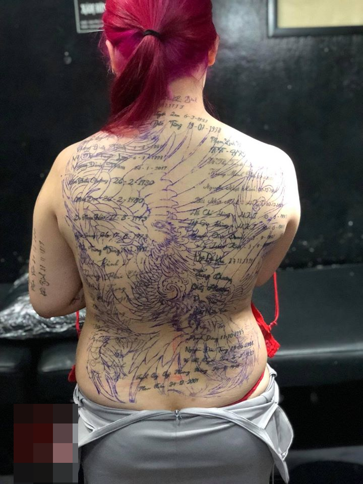  
Thợ xăm đã phác họa hình xăm mới lên tấm lưng của cô gái