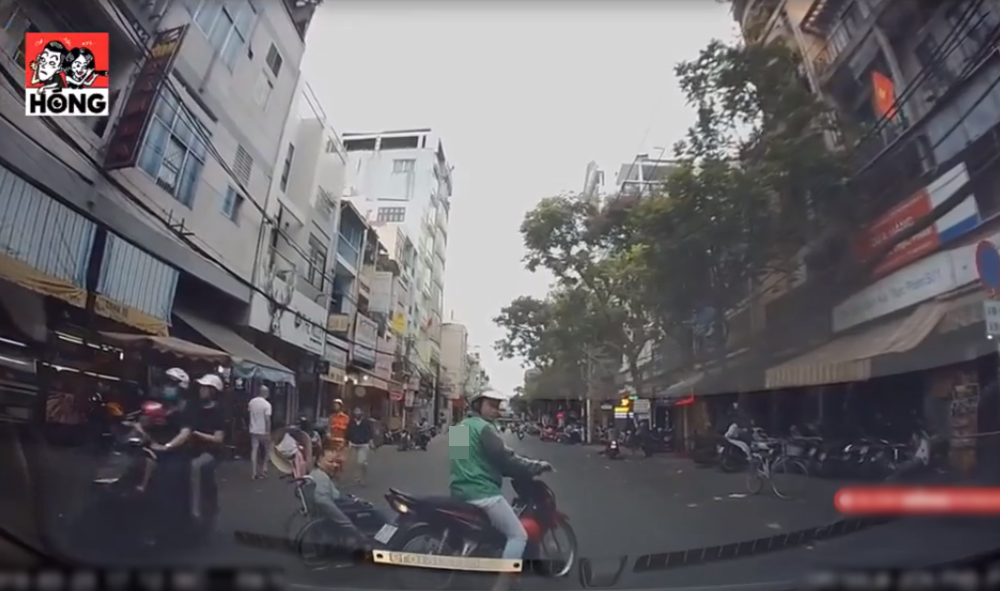  
Anh xe ôm công nghệ biến mình thành "lá chắn" giúp bà cụ ngồi xe lăn qua đường (Ảnh: Facebook Hóng)