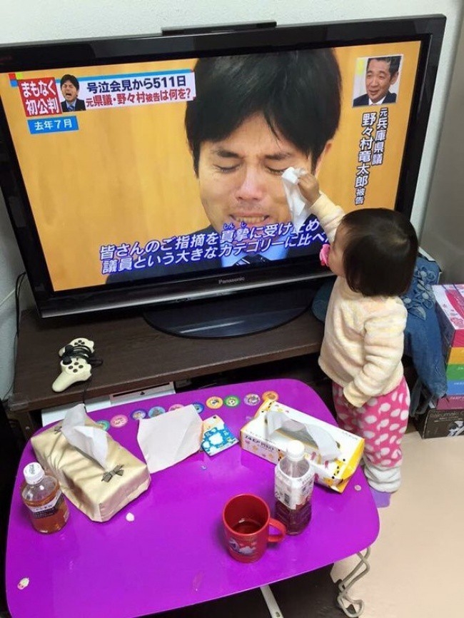  
Em bé người Nhật cầm khăn lâu nước mắt cho người đàn ông trong ti vi, hành động hài hước nhưng thể hiện sự quan tâm đến cảm xúc của những người xung quanh.