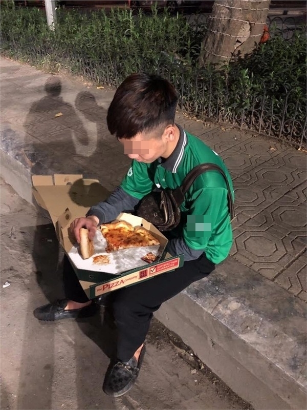  
Anh shipper ngồi ăn hết cái bánh pizza bị khách “bom” hàng. 