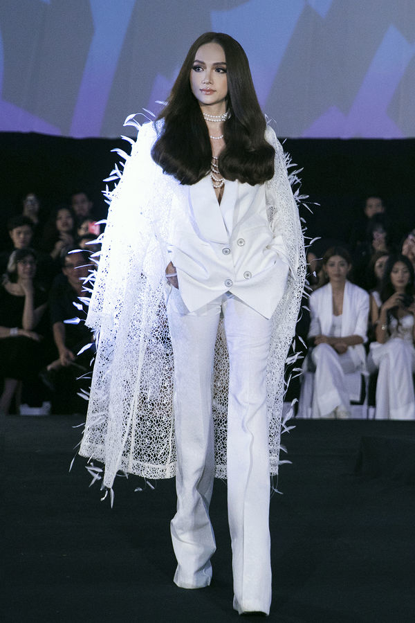  
Trong show diễn thời trang sau đó, Hương Giang diện bộ suit trắng, điểm nhấn của trang phục là áo choàng đính lông vũ khoác ngoài. ​