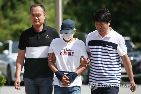  
Nghi phạm Hàn Quốc trong vụ bạo hành vợ người Việt trình diện trước toàn án quận Gwangju sáng 8/7. Ảnh: Yonhap