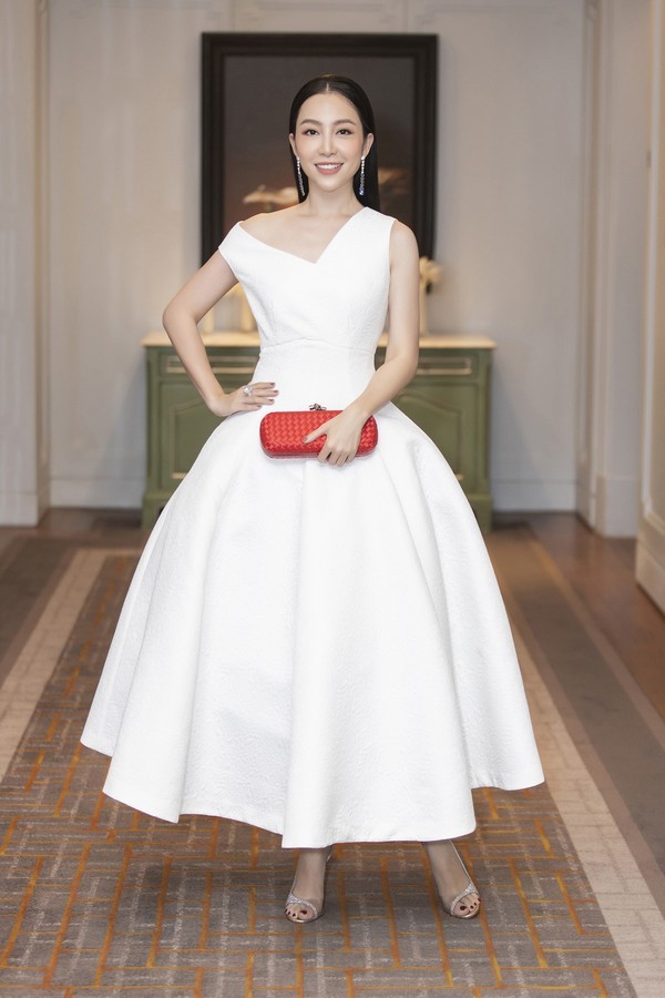  
Linh Nga chọn clutch cầm tay màu đỏ rực phối cùng váy trắng càng tăng thêm sự nổi bật. Chiếc đầm xòe rộng nhưng vẫn không kém phần thanh lịch, thu hút. ​