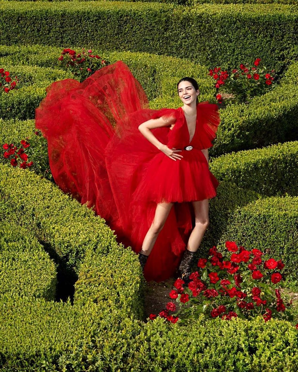  
Chân dài Victoria’s Secret cười rạng rỡ giữa khung cảnh tươi mát của cây xanh và hoa hồng. 