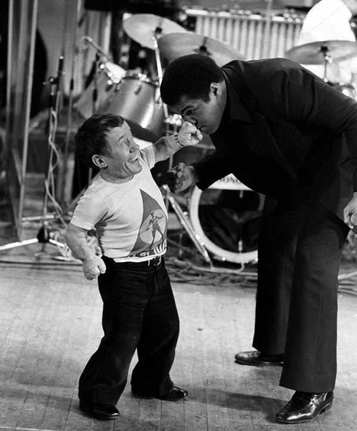 Hay hình ảnh vui nhộn của nam diễn viên, nhạc sĩ Kenny Baker đang cố với tay để "tấn công" vận động viên quyền Anh Muhammad Ali vào năm 1979.