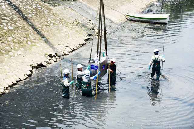  
Công nhân đang tiến hành lắp đặt hệ thống làm sạch nước trên sông Tô Lịch vào ngày 16/5. (Ảnh: Dân trí)