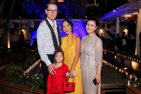  
Gia đình Đoan Trang đến chúc mừng Kim Thư. Giọng ca "Quạt giấy" diện đầm vàng chất liệu lụa đeo túi hiệu đỏ, trong khi chồng Tây lịch lãm với vest. 