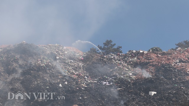 Núi rác khổng lồ vẫn âm ỉ cháy và bốc khói nghi ngút (Ảnh: Dân Việt)