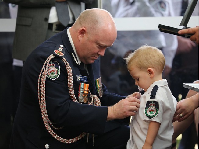 
Hình ảnh con trai lên nhận huy chương thay cho cha đã mất