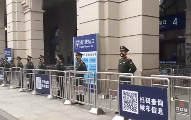  
Cảnh sát đứng trước cửa nhà ga Vũ Hán. Các chuyến tàu tại đây đều đã tạm dừng hoạt động. (Ảnh: Weibo).