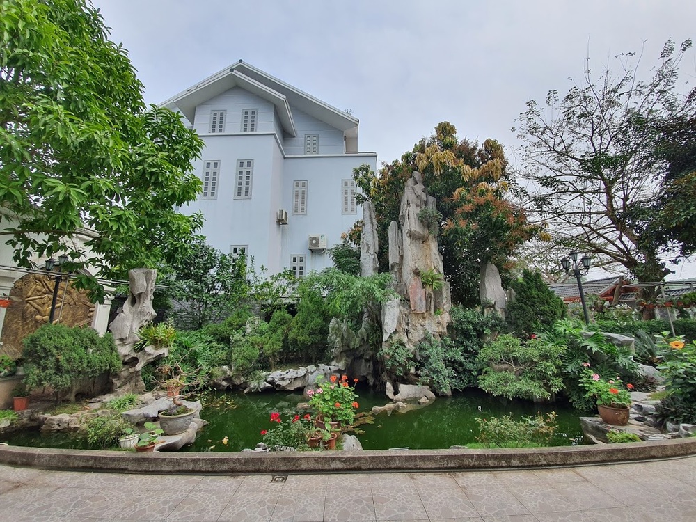  
Bên ngoài ngôi nhà là hệ thống sân vườn với nhiều loại cây, hoa và bể cá được thiết kế công phu.